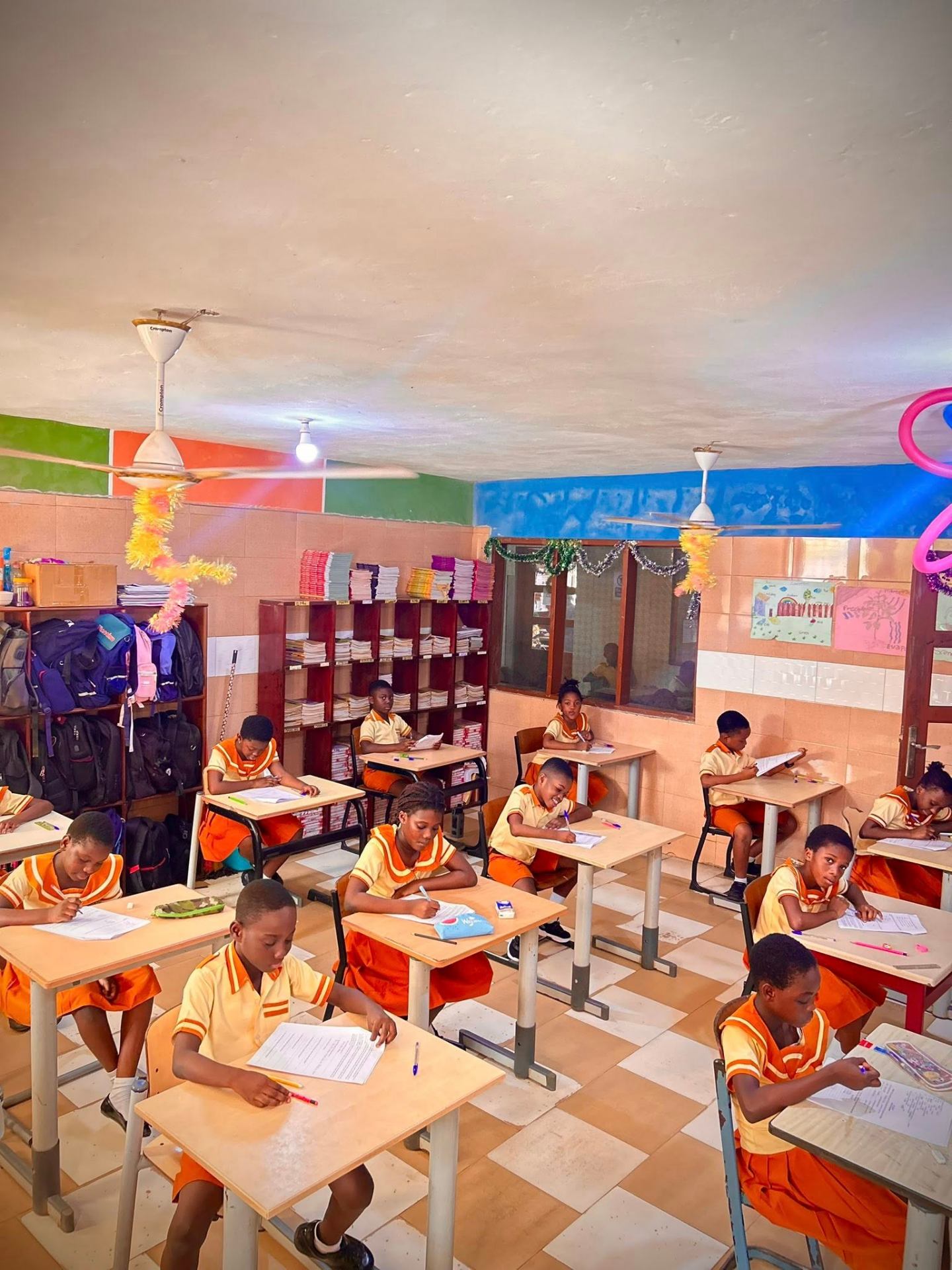 KKMS students in orange uniforms studying in class